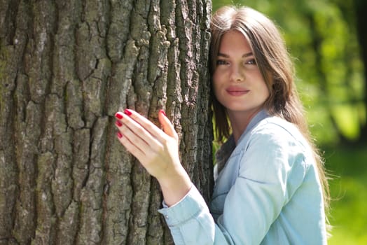 Young woman hugging a big tree, love nature concept