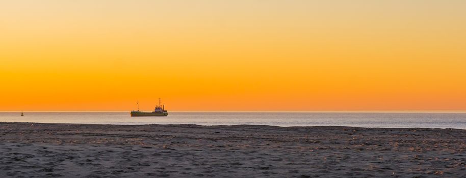 ship sailing in the ocean at sunset, colorful orange sky, nature and transport background