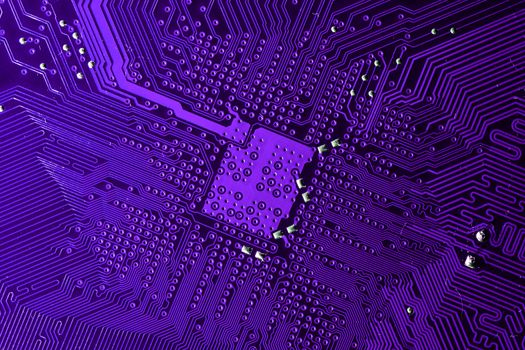Close up photo of purple printecd circuit board with solder points