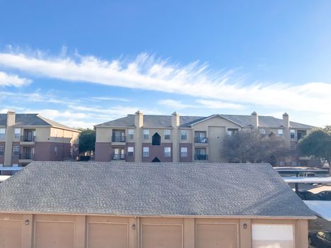 Aerial view of apartment complex with cover parking and detached garage in North Texas, America. Cloud sky at sunset