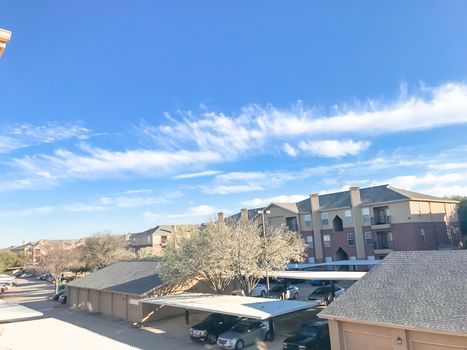 Typical aerial view of apartment complex with cover parking and detached garage in North Texas, America. Cloud sky at sunset in spring time with Bradford  pear flower blooming