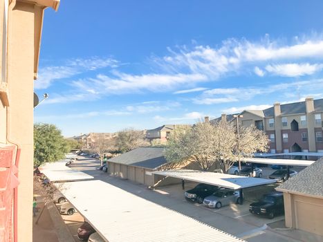 Typical aerial view of apartment complex with cover parking and detached garage in North Texas, America. Cloud sky at sunset in spring time with Bradford  pear flower blooming