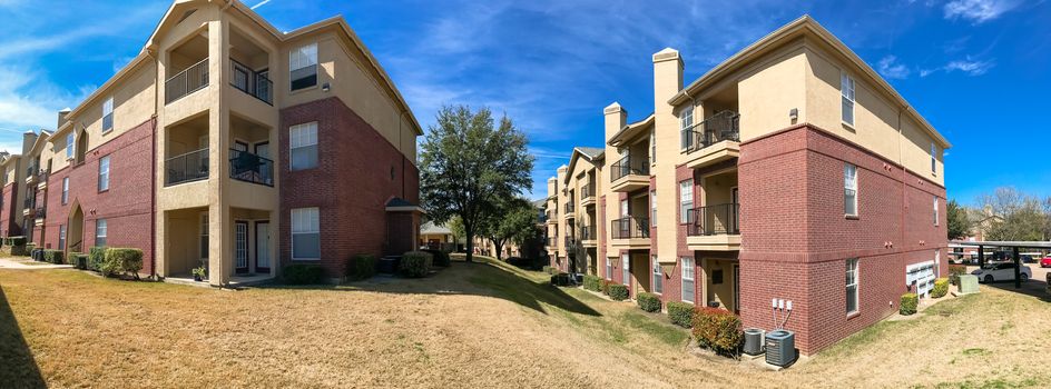 Panorama view modern apartment complex building with steep backyard in Lewisville, Texas, USA. Sunny spring day with cloud blue sky