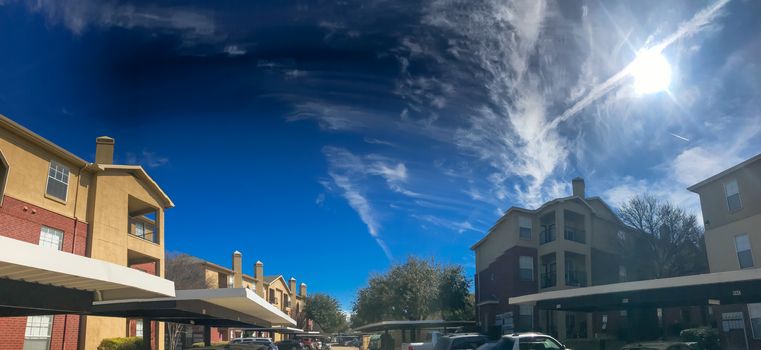 Typical panorama view modern apartment complex building with covered parking in Lewisville, Texas, USA. Sunny spring day with cloud blue sky