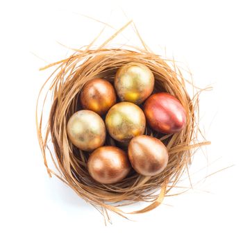 Happy Easter holiday greeting symbol natural wooden grass nest with golden quail eggs studio isolated on white background