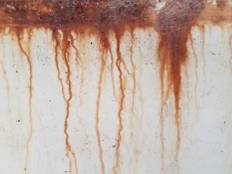 rown or red rust dripping down grey cement wall