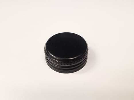 circular black metal bottle cap on white surface or table