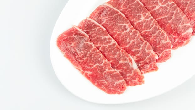 Top view of some raw beef on a plate over white background