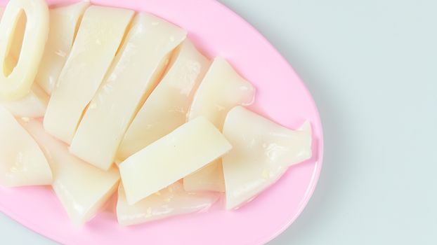 top view raw squid sliced on pink plate