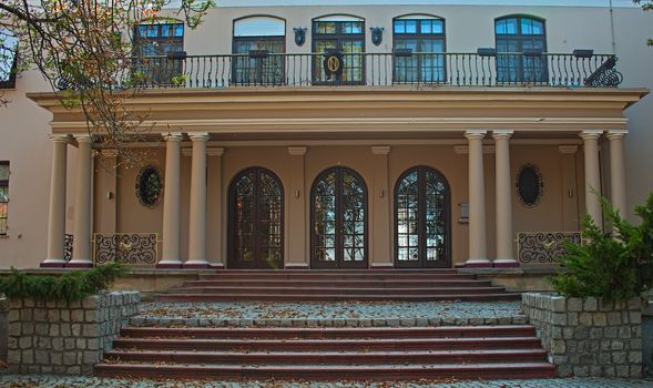 Outside view on entrance into villa with doors, stairs and windows