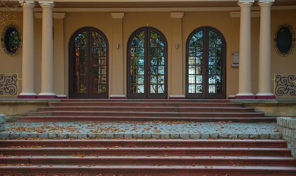 Outside view on entrance into villa with doors and stairs