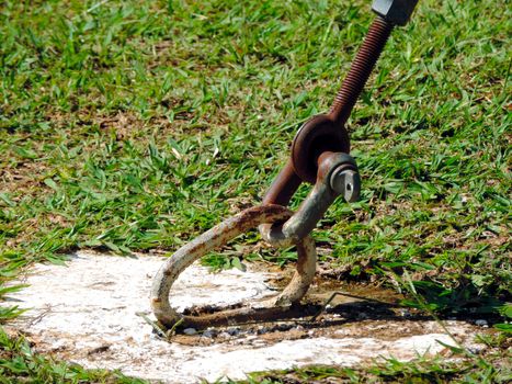 Metal and rusty anchor attached to the ground