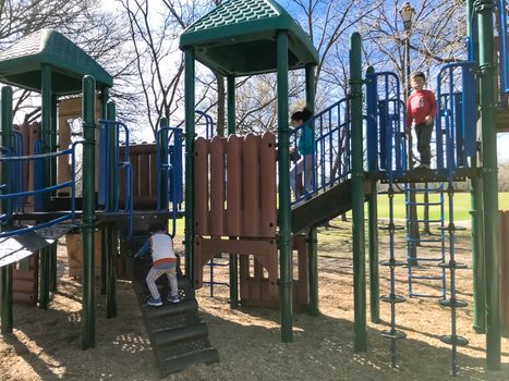 Kids running at colorful playground during wintertime in Lewisville, Texas, USA.