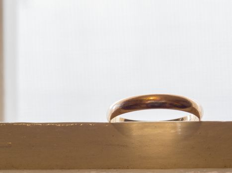 Only an old wedding ring, in gold, on a white dresser