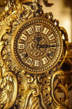 Detail of a beautiful vintage clock in the baroque style in brass.