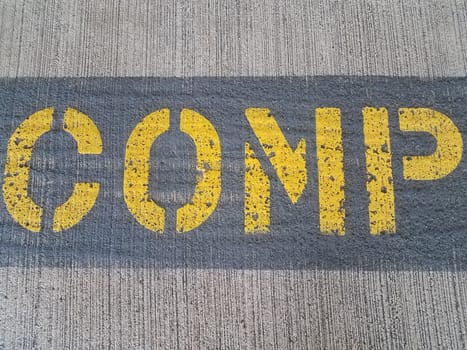 yellow word comp on grey cement ground or floor or pavement