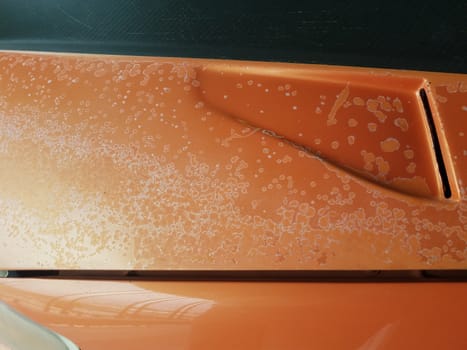 corrosion or damage on weathered orange car or automobile