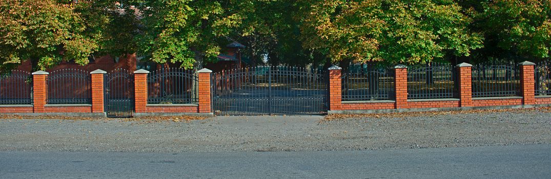 Simple metal fence with red bricks wall and pillars