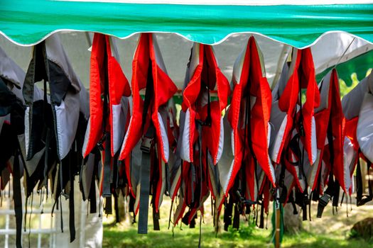 Life jackets drying in the summer shed neat the river in Latvia. Life jackets on the Gauja shore.