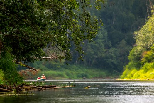 People boating on river Gauja in Latvia, peacefull nature scene. By boat through the river. Boat trip along the Gauja River in Latvia. The Gauja is the longest river in Latvia, which is located only in the territory of Latvia. Length - 452 km.



