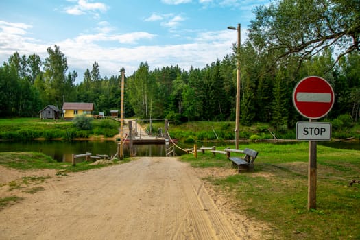 Ligatne ferry crossing on the bank of river Gauja. Ferry across river in Latvia. The ferry over Gauja river is the only crossing of this type in the Baltic States. Ferry is made of two boats fastened together on which there is a plank layer. Road sign "Do not enter".

