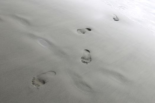 Footprints from the feet of a woman or man on the sand of the beach