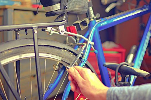 Man repair bicycle. Adjusting bike to prepare for the new bike season. 