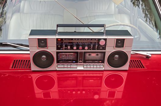 Device for sound playback and recording is on the hood of a retro car.