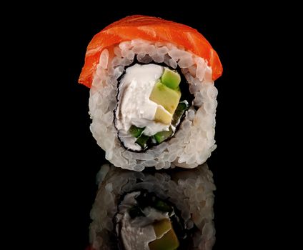 In front single sushi roll Philadelphia. Black background with reflection.