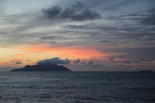 uninhabited island in the ocean against the sunset