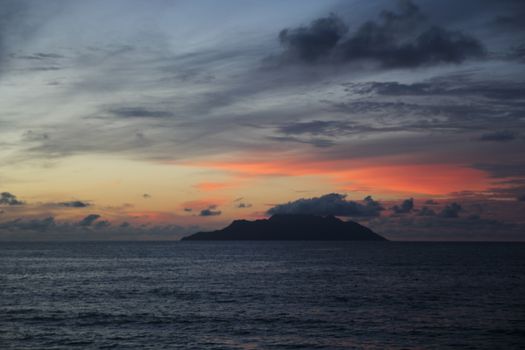 uninhabited island in the ocean against the sunset