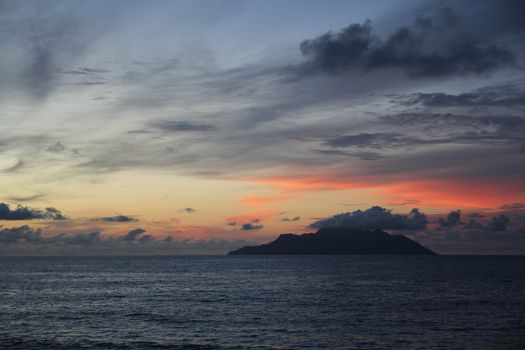 uninhabited island in the ocean against the sunset