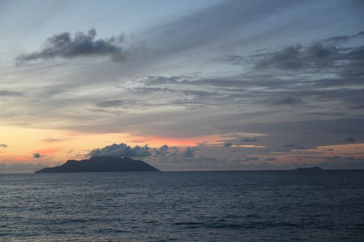 uninhabited island in the ocean against the sunset