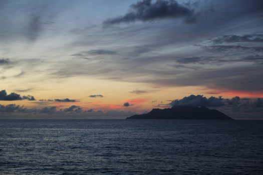 uninhabited island in the ocean against the sunset