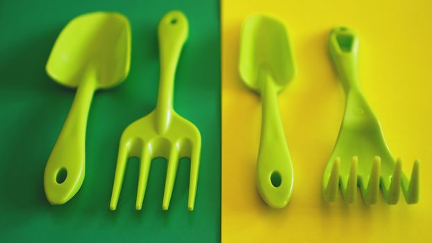 Set of green garden tools on green and yellow background - soft focus