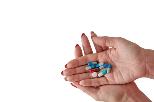 Colored assorted pharmaceutical medicine pills, tablets and capsules on female hand isoleted on white background. Close-up.