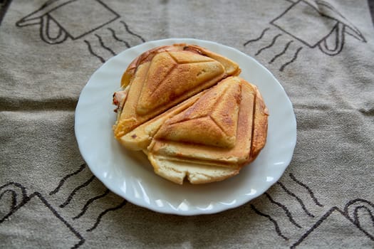 Hot Crispy Sandwich. Fresh hot crispy delicious toaster on a white plate for breakfast. Food for breakfast. Vegetarian food.