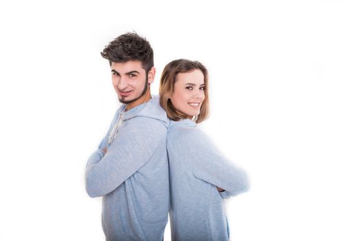 Smiling young man and woman are standing back each other, isolated on white