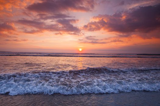 Amazing colorful sunset over sea form Bali beach