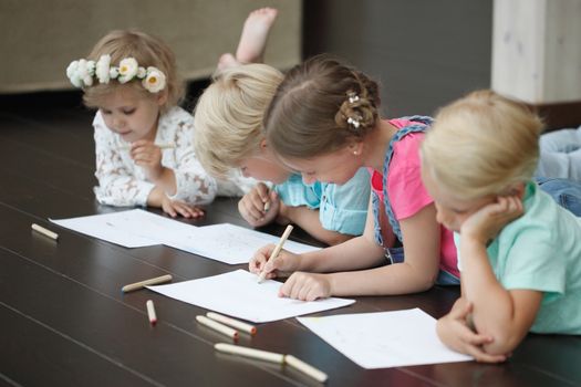 Group of cute children drawing with colorful pencils on floor
