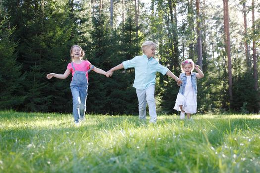 Group of young children running towards camera in park