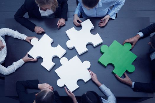 Group of business people assembling jigsaw puzzle, team support and help concept
