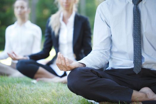 Business people practicing yoga in park