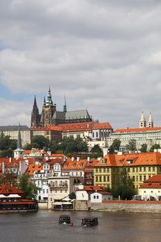 View of Prague lesser old town with Royal castle palace and Saint Vitus Cathedral over Vltava river and blue sky
