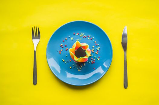 Colorful food on blue plate with fork and knife