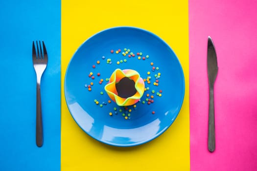 Colorful food on blue plate with fork and knife