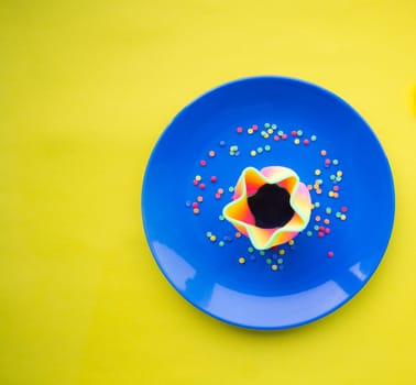 Blue plate with some sort of dessert on yellow background with copy space