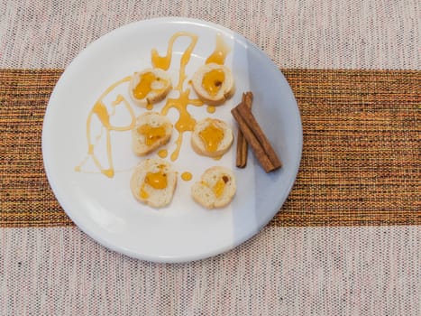 Healthy and diet food, small slices of toast with honey and cinnamon, on striped plate on table with cotton towel