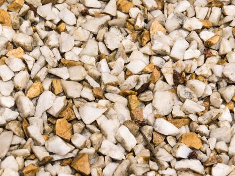 Close view of wet floor of white pebbles, and light brown, after summer rain