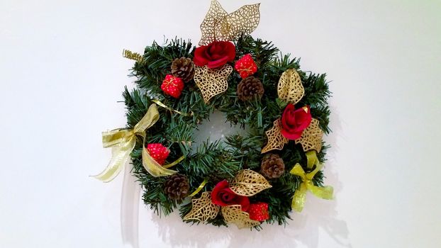 New Year's wreath of fir branches, pine cones and red roses.